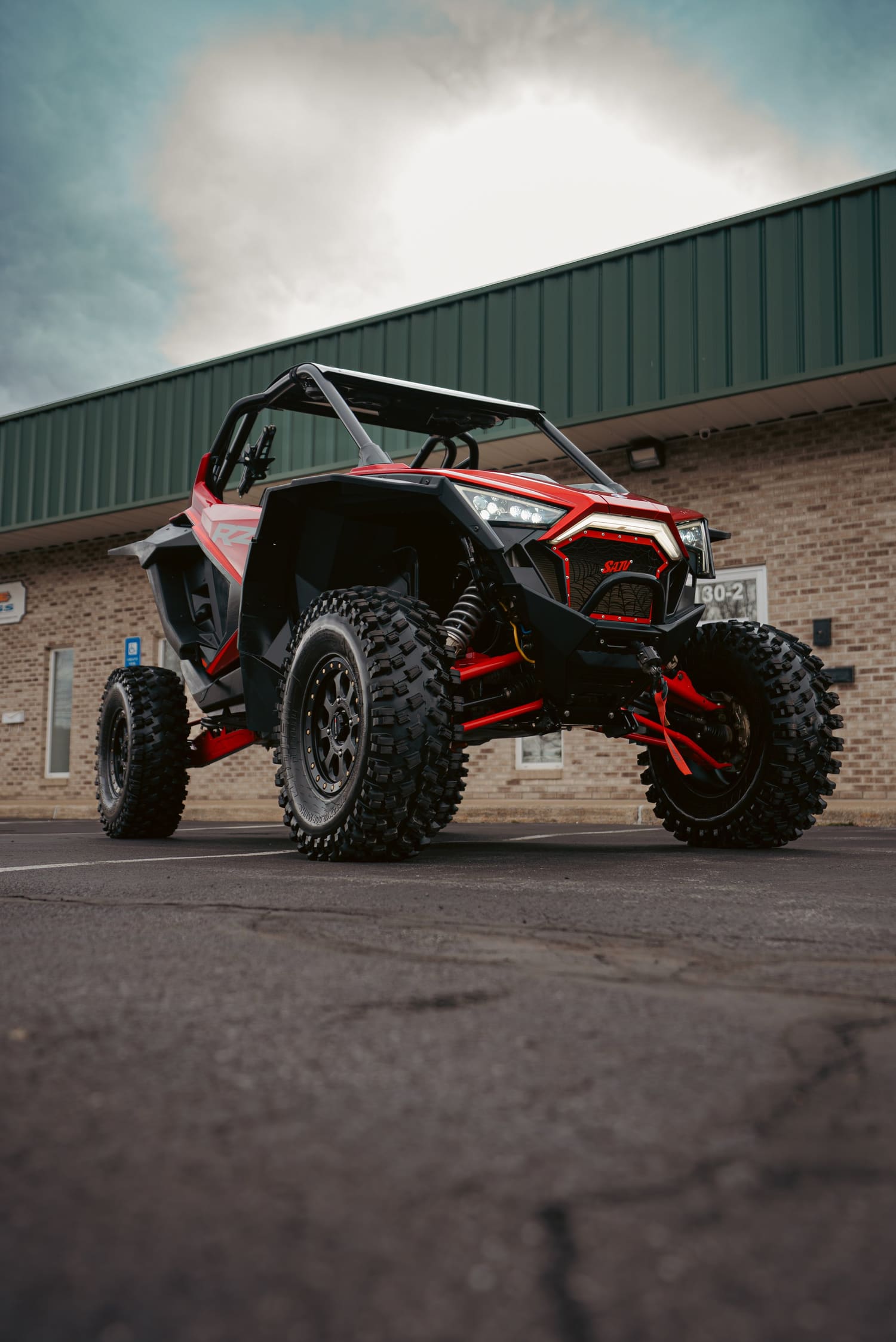 Red and black off-road side-by-side parked outside the C4 shop