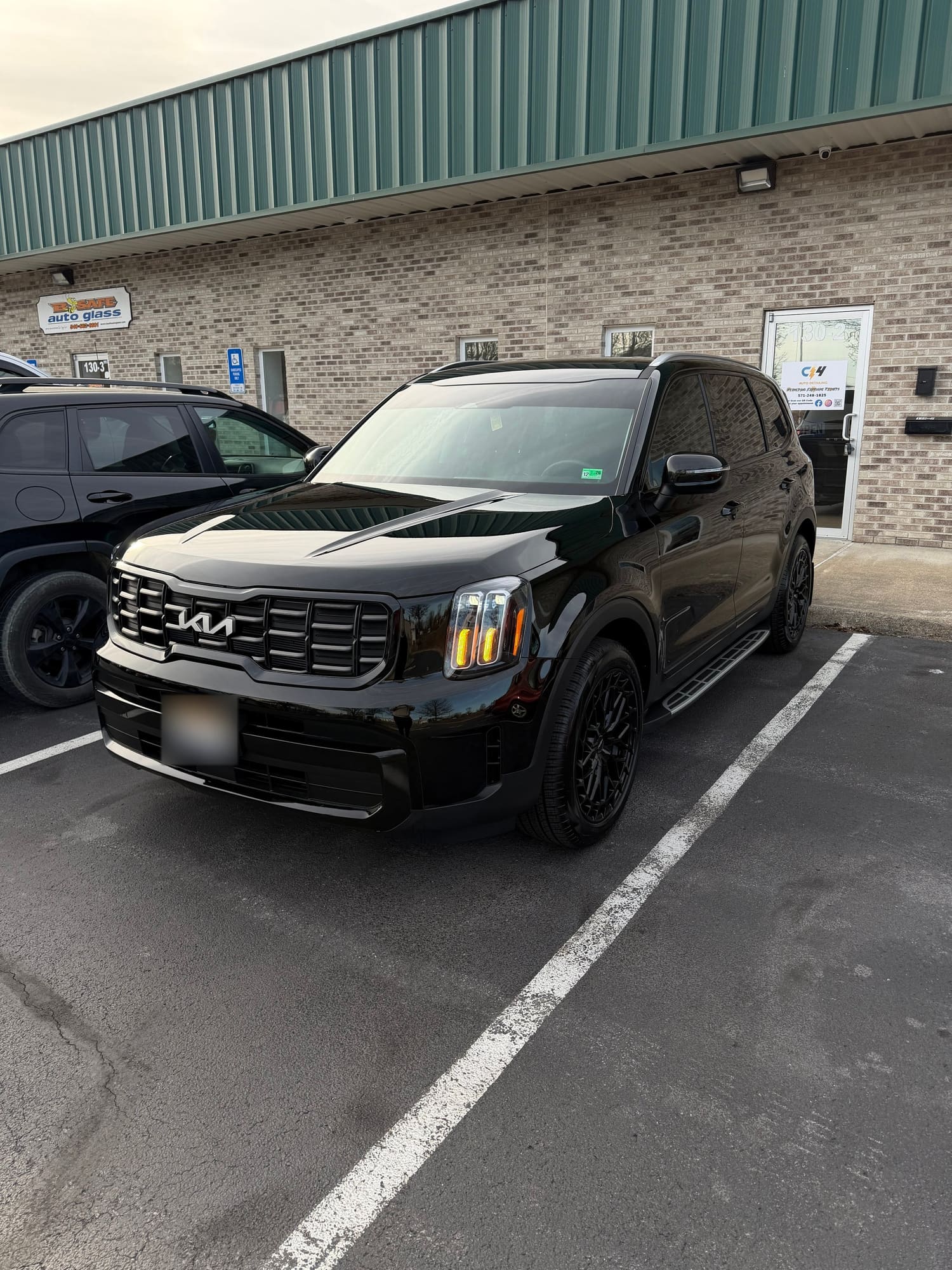 Black Kia Telluride parked outside the C4 shop