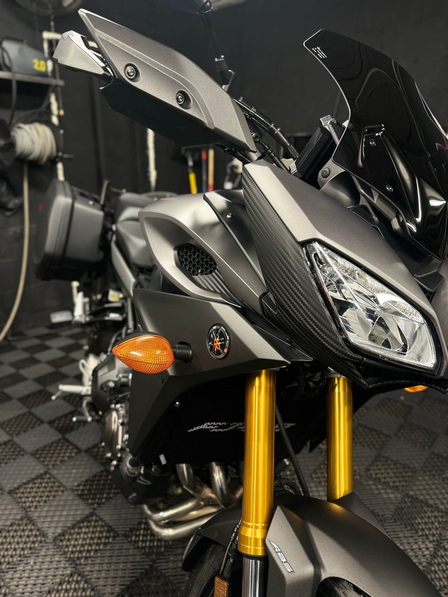 Close-up of a gray and black motorcycle with gold front forks